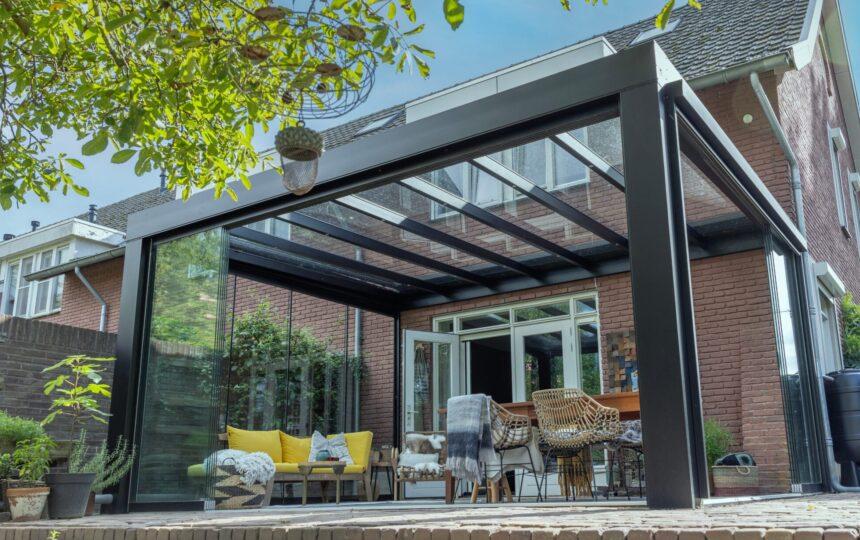 Veranda met glazen dak en schuifwanden tegen de achtergevel van een woning